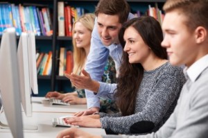 Tutor Helping Teenage Students Working At Computers