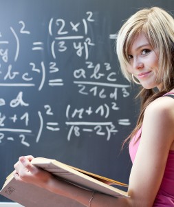 pretty young college student writing on the chalkboard/blackboar